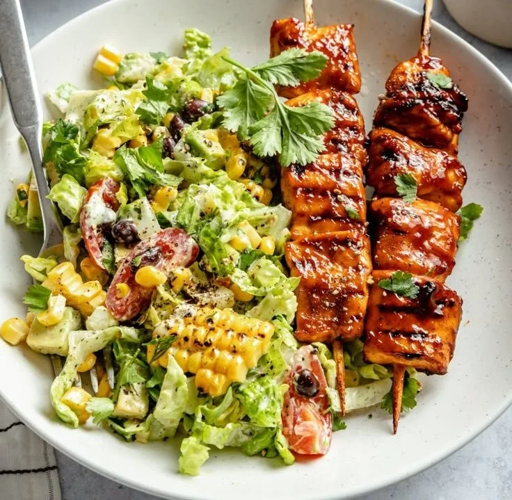BBQ chicken skewer salad with fresh vegetables and vibrant dressing