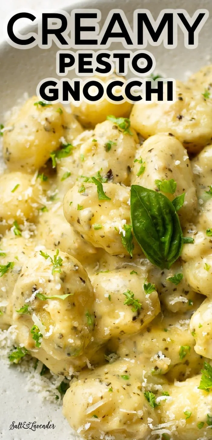 Creamy pesto gnocchi served in a bowl with fresh basil and parmesan cheese
