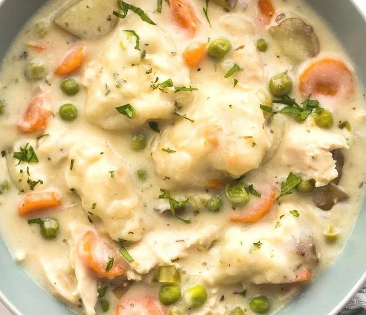 Crockpot Chicken and Dumplings served in a bowl with fresh herbs