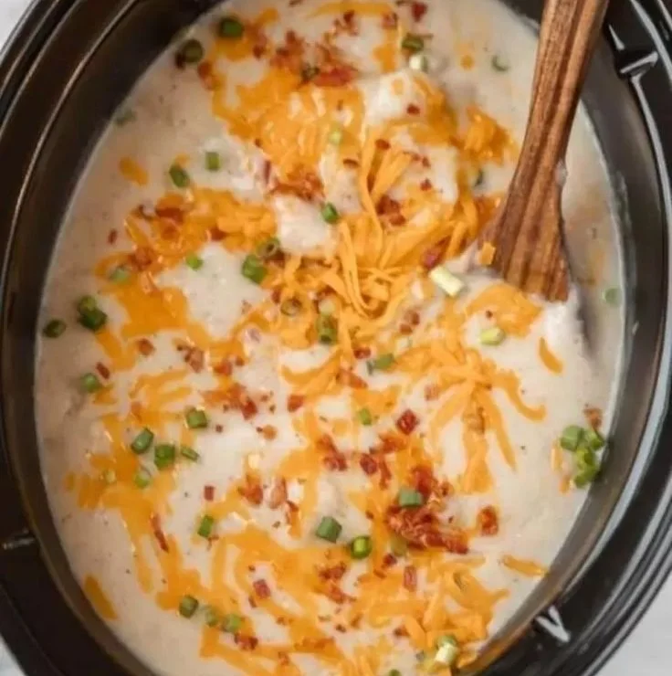 Bowl of creamy Crockpot Loaded Potato Soup garnished with cheese and bacon