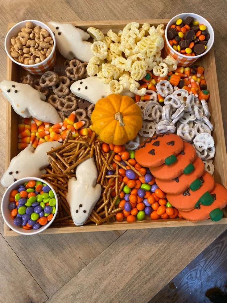 Spooky Halloween Charcuterie board with themed treats and decorations.