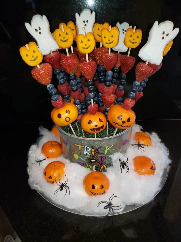Spooky Halloween party fruit display with ghostly designs and vibrant colors.
