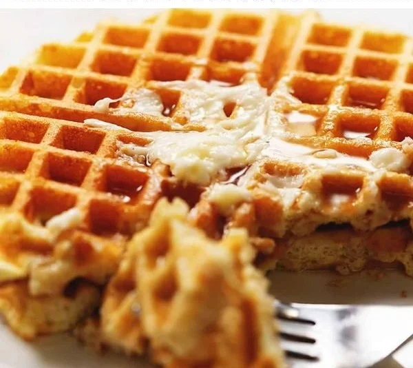 High protein waffles topped with fresh berries and maple syrup