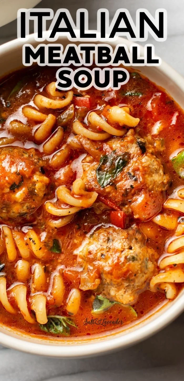 Bowl of hearty meatball soup with fresh herbs and vegetables