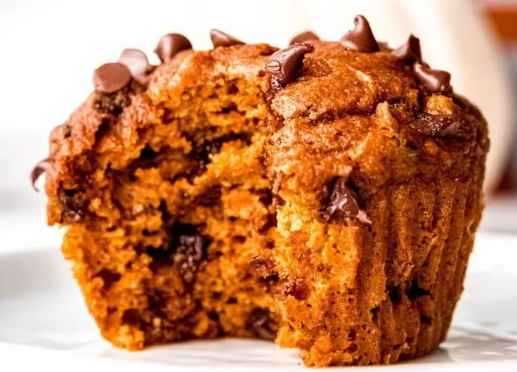 Healthy Pumpkin Protein Muffins on a wooden table, ideal for breakfast.