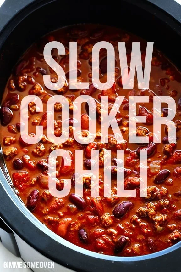 A bowl of slow cooker chili garnished with cilantro and shredded cheese.