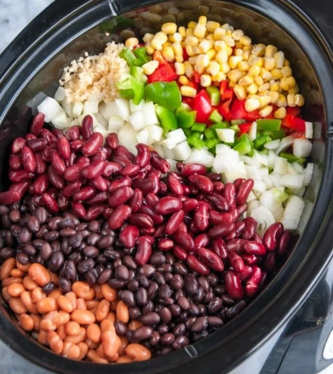 Bowl of Slow Cooker Three Bean Chili garnished with fresh herbs