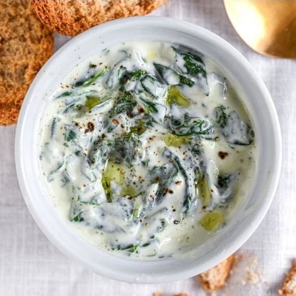 Delicious spinach dip served in a vibrant bowl with fresh veggies for dipping
