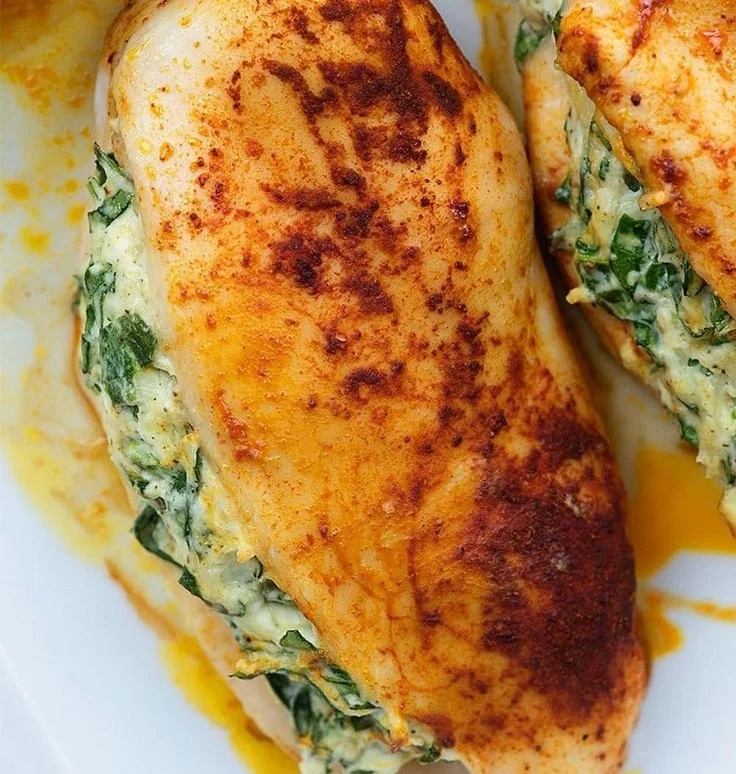 Delicious spinach stuffed chicken breasts served on a white plate