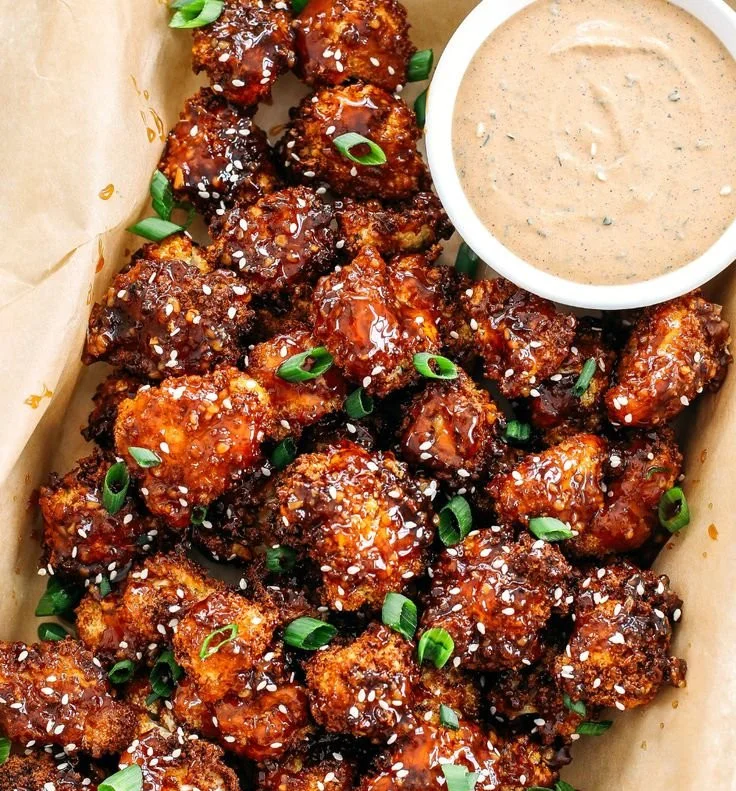 Sticky honey garlic cauliflower wings served on a plate with garnish