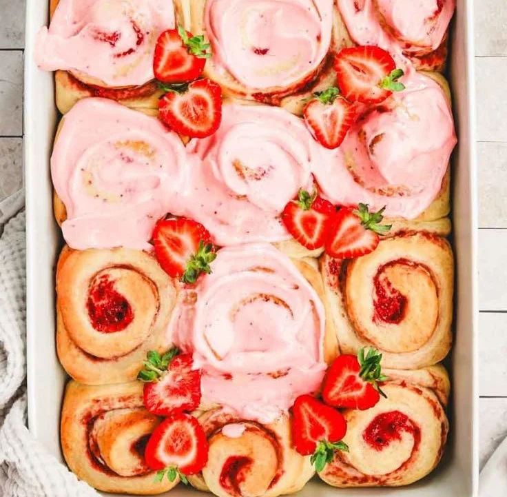 Freshly baked strawberry cinnamon rolls with cream cheese icing on top