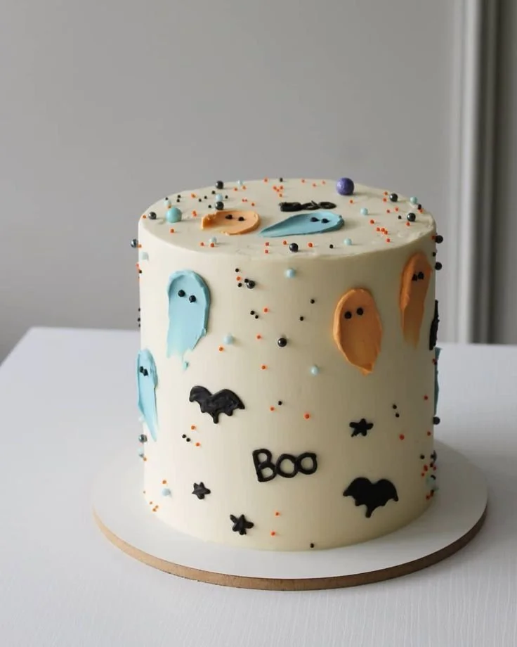 Cute Halloween birthday cake with ghosts and colorful sprinkles