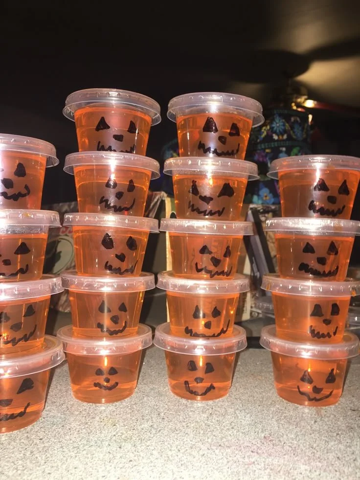 Colorful Halloween Jell-O shots in spooky themed cups