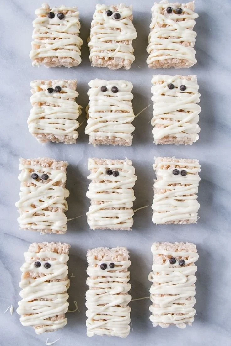 Colorful Halloween snacks and treats for kids at a party table.