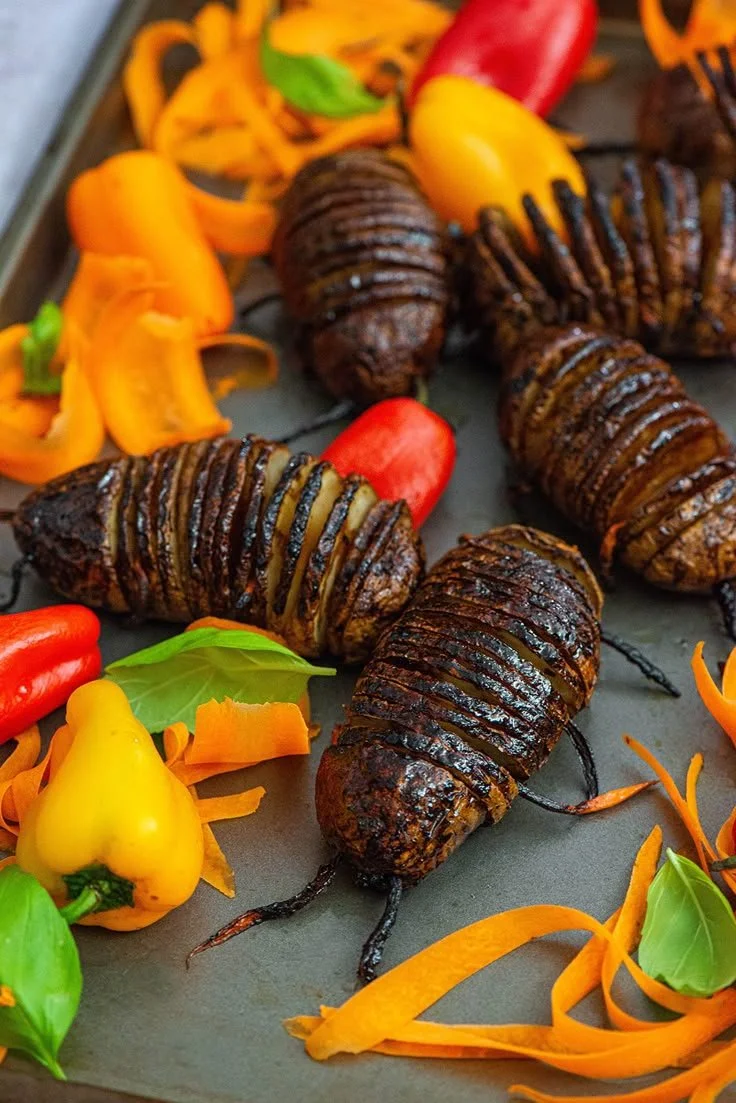 Delicious Hasselback Potatoes served with creative bug toppings for Nibbles and Feasts