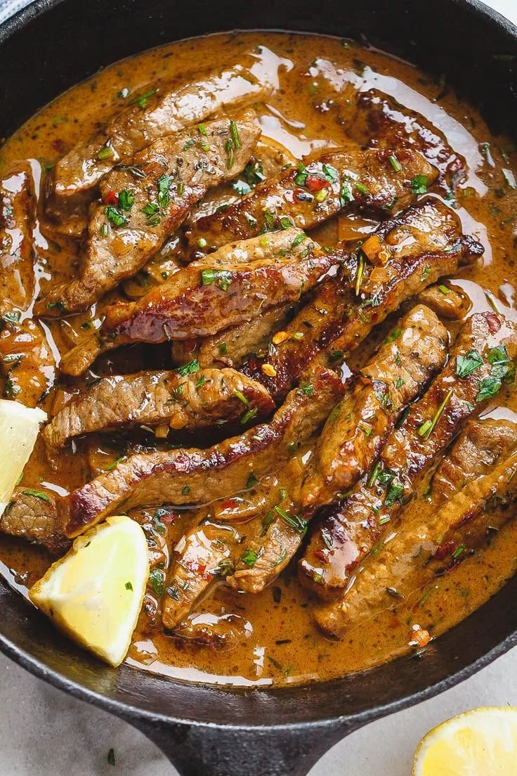 Delicious pan-seared steak in rich butter sauce on a plate.