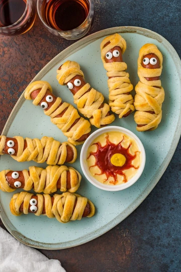 Spooky Halloween pasta mummies and hot dogs for festive dining.