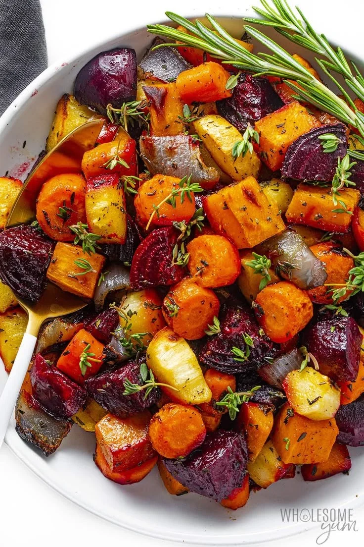Colorful roasted root vegetables including beets and carrots in a serving dish.