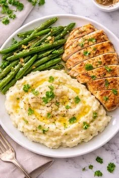 Bowl of creamy mashed potatoes with celery, garnished with herbs