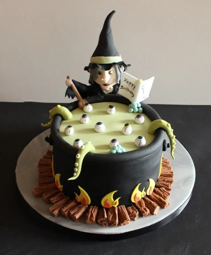 Witch on top Halloween cake decorated with spooky themes and vibrant colors